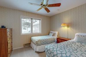 a bedroom with two beds and a ceiling fan at Golfer's Villa in Bigfork