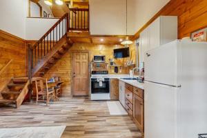 a kitchen with a white refrigerator and a staircase at Moose and Bear in Bigfork