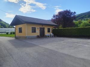 a small yellow house with a patio in a driveway at apartma Grad in Motnik