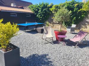 a patio with chairs and a ping pong table at La marine D'opale in Ambleteuse