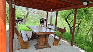 a wooden table and chairs sitting under a gazebo at Casa Berbece in Moieciu de Jos
