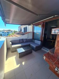 a patio with a couch and a table on a balcony at Apartman SEA VIEW in Vantačići