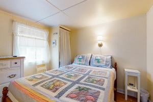 a bedroom with a bed with a quilt on it at The Eastern Avenue Cottage in Wells Beach
