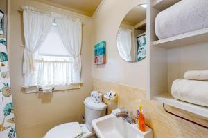 a bathroom with a toilet and a sink and a window at The Eastern Avenue Cottage in Wells Beach +56 photos
