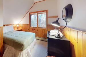 a bedroom with a bed and a desk with a lamp at Sunday River Village Timberline in Newry