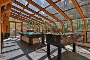 a room with a ping pong table and a glass ceiling at Sunday River Village Timberline in Newry