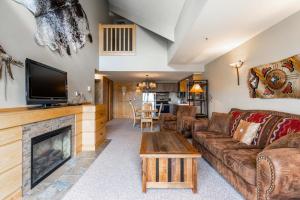 a living room with a couch and a fireplace at Shoshone 1986 in Big Sky