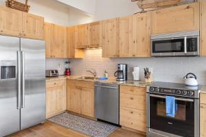 a kitchen with wooden cabinets and stainless steel appliances at West Willow 5 in Telluride