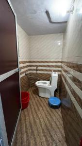 a bathroom with a toilet in a room at Khushraali hotel and restaurant in Rudraprayāg