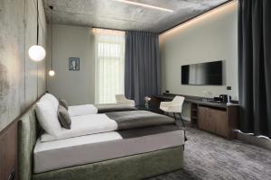 a bedroom with a bed and a desk and a television at Hotel Zator in Zator