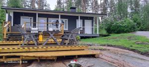 a small house with chairs on a wooden deck at Suvikoti in Lokalahti