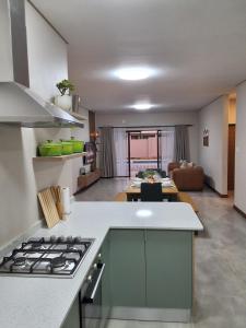 a kitchen with a stove and a living room at Natures Nest with Mongi Hazyview in Hazyview
