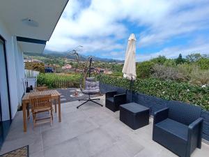 a patio with a table and chairs and an umbrella at Casa da Mãe in Santana