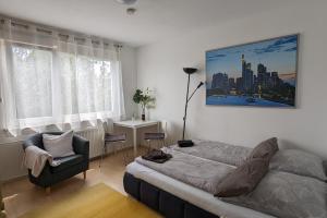 a bedroom with a bed and a chair at Ferienwohnung Bad Vilbel in Bad Vilbel