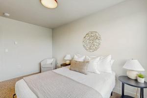 a white bedroom with a bed and a blue table at Mod Haus 2 in Kalispell