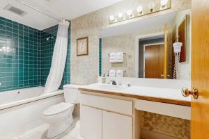 a bathroom with a toilet and a sink and a tub at South Peak Efficiency At Rivergreen in Lincoln +23 photos