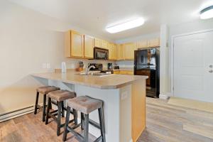 a kitchen with a large island with bar stools at First Tracks Fun in Steamboat Springs