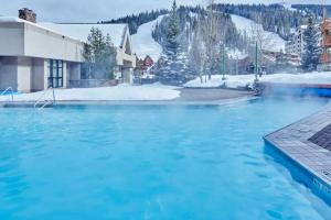 a pool of blue water with a snow covered mountain at Shoshone 1960 in Big Sky