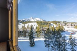 a view of a snow covered mountain from a window at Shoshone 1954 in Big Sky