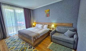 a hotel room with a bed and a chair at Sunshine Kazbegi in Kazbegi