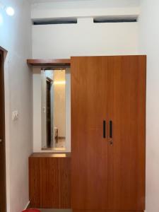 a room with a wooden cabinet and a mirror at IB homes in Changanācheri