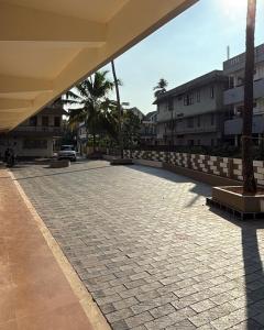 an empty courtyard with palm trees and buildings at IB homes in Changanācheri