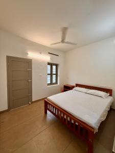 a bedroom with a bed and a window and a door at IB homes in Changanācheri