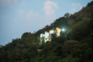 a house on a hill with a light on it at The Cloud by Daan in Vagamon