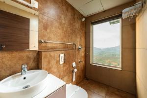 a bathroom with a sink and a shower and a window at The Cloud by Daan in Vagamon