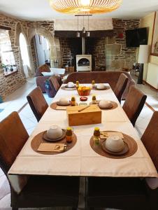 a dining room with a large table with chairs at Bienvenue à Longère Bihan - Chambres d'Hôtes - Bed & Breakfast in Plévin