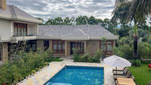 a house with a swimming pool in front of a house at Uyoga House in Arusha