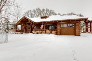 a log cabin in the snow with a snow covered yard at Teton View Cabin in Jackson