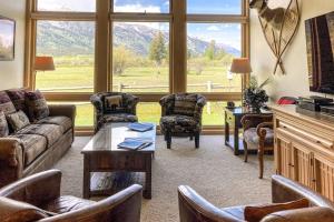 a living room with couches and chairs and a large window at 4412 Mackinaw in Wilson