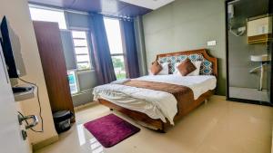 a bedroom with a large bed in a room with windows at Hotel sunshine in Kānpur