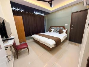a bedroom with a bed and a television in it at Hotel sunshine in Kānpur