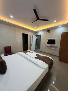 a bedroom with a large bed with a ceiling fan at Hotel sunshine in Kānpur