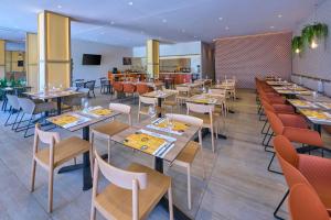 a dining room with tables and chairs and a restaurant at City Express Plus by Marriott Puerto Vallarta in Puerto Vallarta