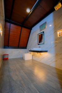 a large room with a white wall and a table at Haven Crest Sinharaja in Deniyaya