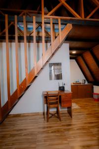 a dining room with a table and a staircase at Haven Crest Sinharaja in Deniyaya