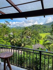 a balcony with a table and a view of the jungle at Haven Crest Sinharaja in Deniyaya