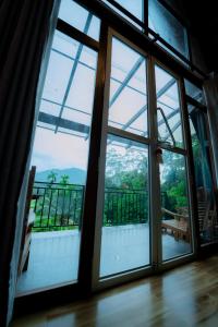 an open glass door with a view of a balcony at Haven Crest Sinharaja in Deniyaya