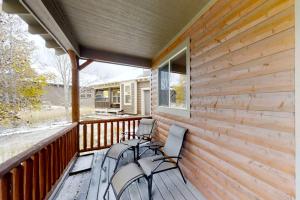a covered porch with two chairs and a window at Deer Track Retreat in Granby