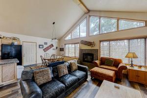 a living room with a leather couch and a table at Hemlock Cabin in Granby