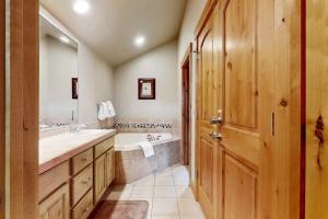 a bathroom with a tub and a sink and a mirror at The Antlers 401 in Winter Park +51 photos