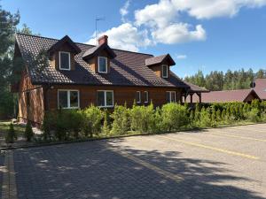 a house with a black roof on a street at "Rowerowa Przystań" turystyka wiejska & agroturystyka nad jeziorem Serwy w sercu Puszczy in Sucha Rzeczka