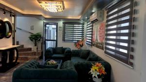 a living room with a couch and two chairs at Cai Residence - Stylish 2BR Staycation near EK & Tagaytay Gateway in Santa Rosa