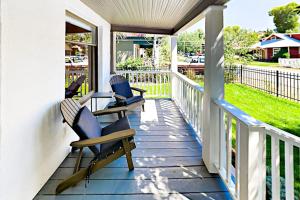 a porch with three chairs and a table on it at Old Town Cottage in Steamboat Springs