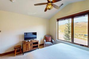a bedroom with a bed and a tv and a window at Bangtail Getaway in Steamboat Springs