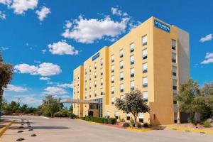 an exterior view of a hotel with a blue sky at City Express by Marriott Cananea in Cananea
