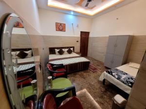 a room with two beds and chairs in it at The Oasis inn in Karnaprayāg